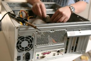 Hands repairing a hard drive.